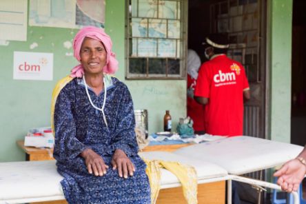 Woman sitting on a couch in front of a health centre
