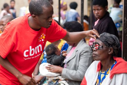 Ein Mann untersucht die Augen einer Frau mit Refaktionsbrille