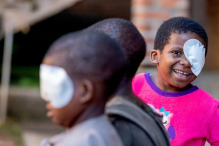 Three children with bandages on their eyes