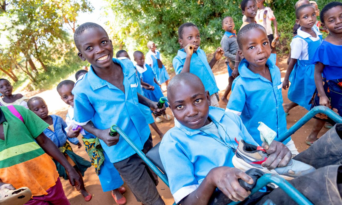 Rashid, 13, who has cerebral palsy, is pushed home in his wheelchair after school in Lilongwe district, Malawi. Rashid receives support from CBM partner Saint John of God rehabilitation technician Clement Mkhomanya.