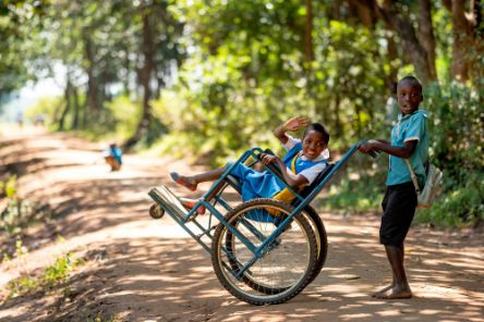 Eight-year-old Sherifa, who lives with cerebral palsy, with a friend on their way home from school in Lilongwe District, Malawi.