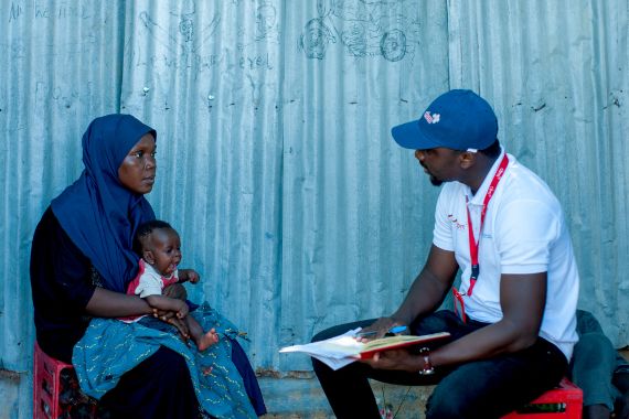 Musa Yunana Bwala, the Humanitarian MEAL Officer at CBM Nigeria, discusses the situation with Nana during a rapid assessment at Bakasi IDP Camp in Maiduguri, Nigeria. This assessment was part of efforts to provide support to people affected by flash floods in the area.