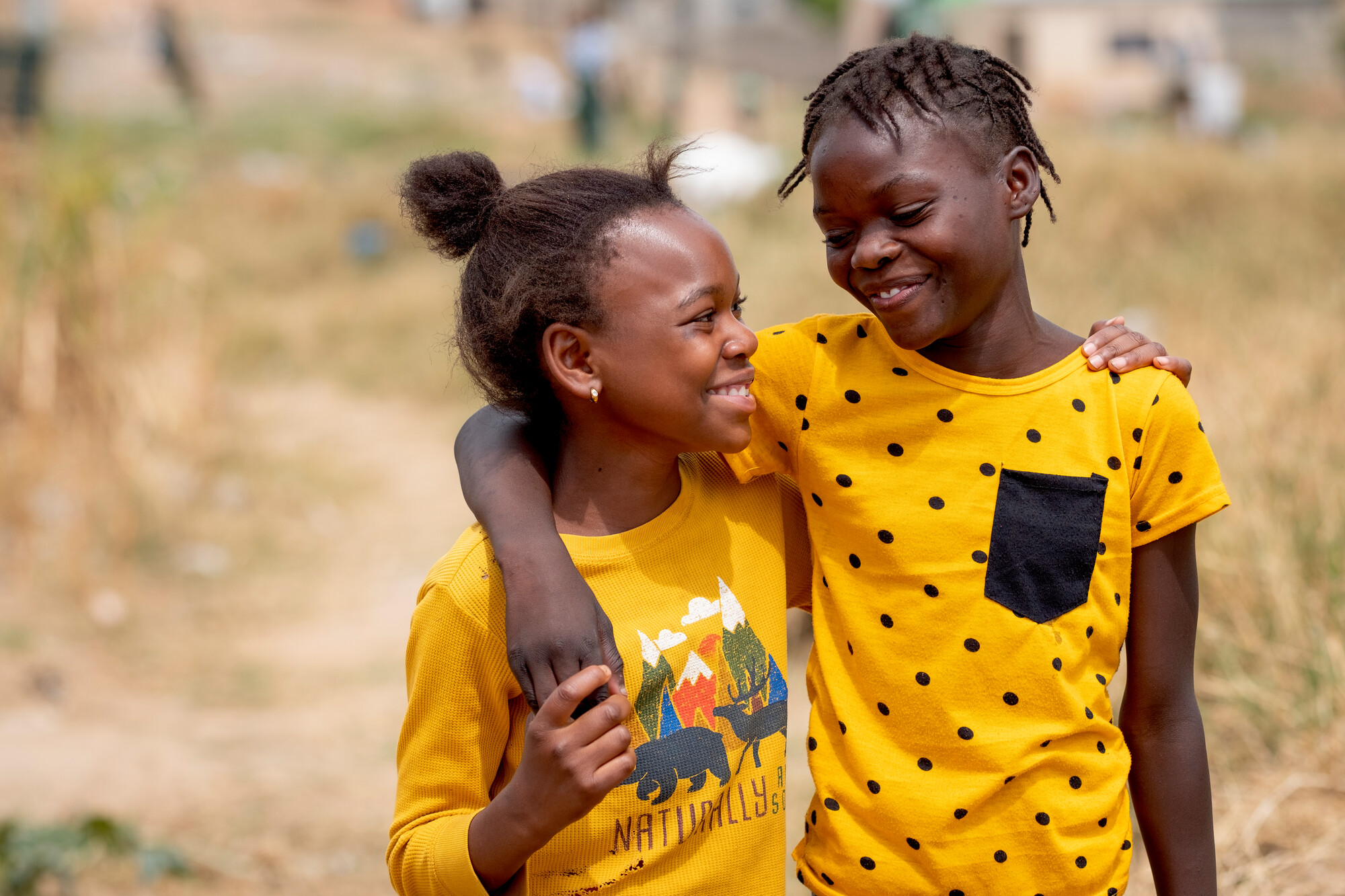 Two girls wearing yellow walking together 