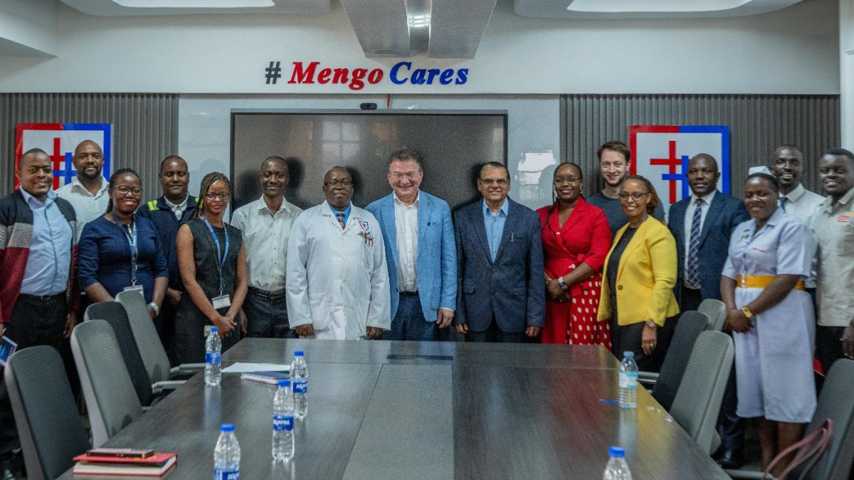 A group of people standing in a boardroom. 