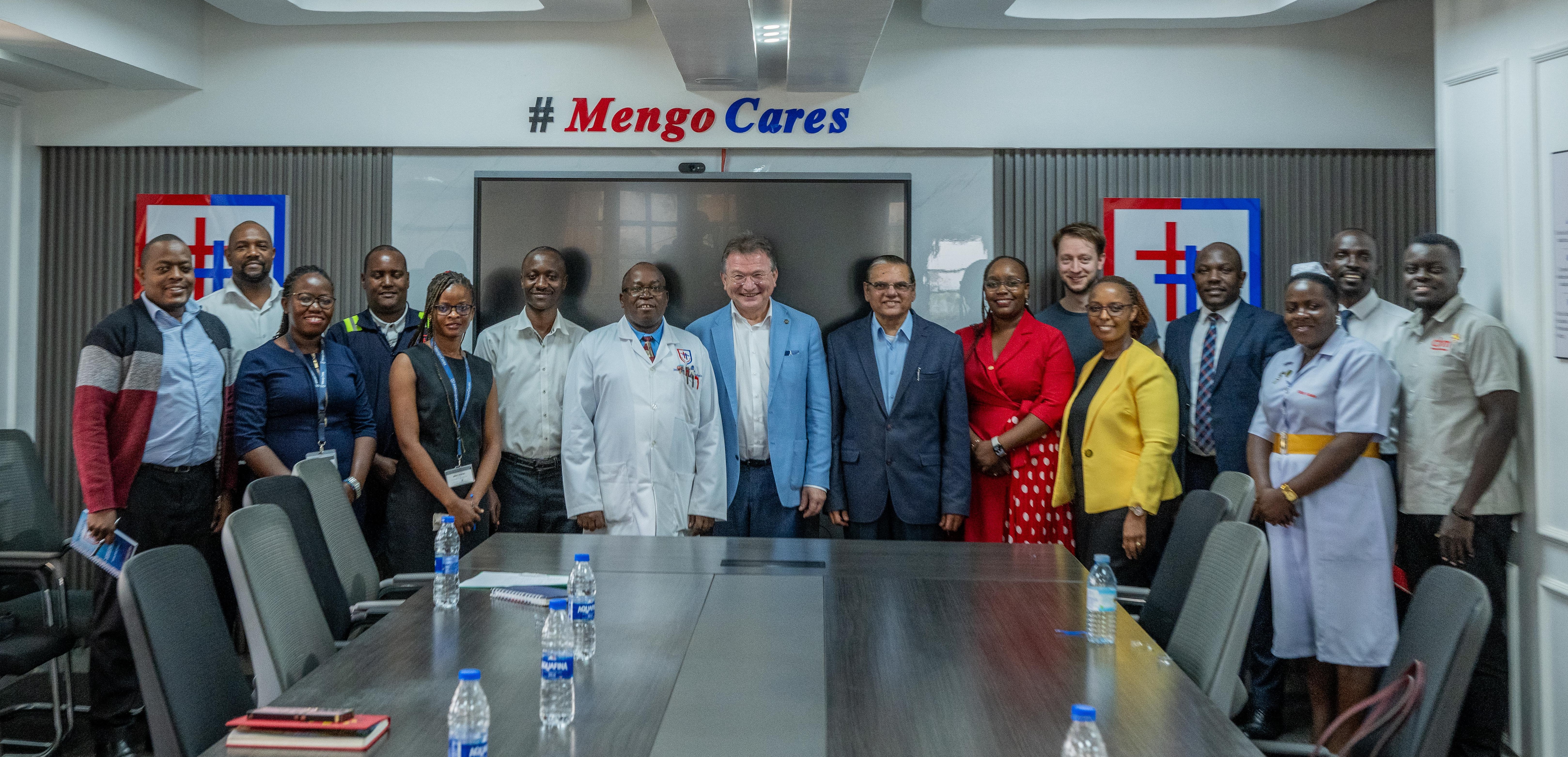 A group of people standing in a boardroom. 