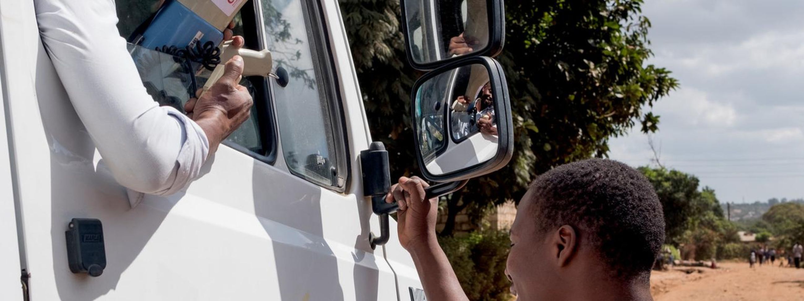 African man with megaphone looking out of the car window