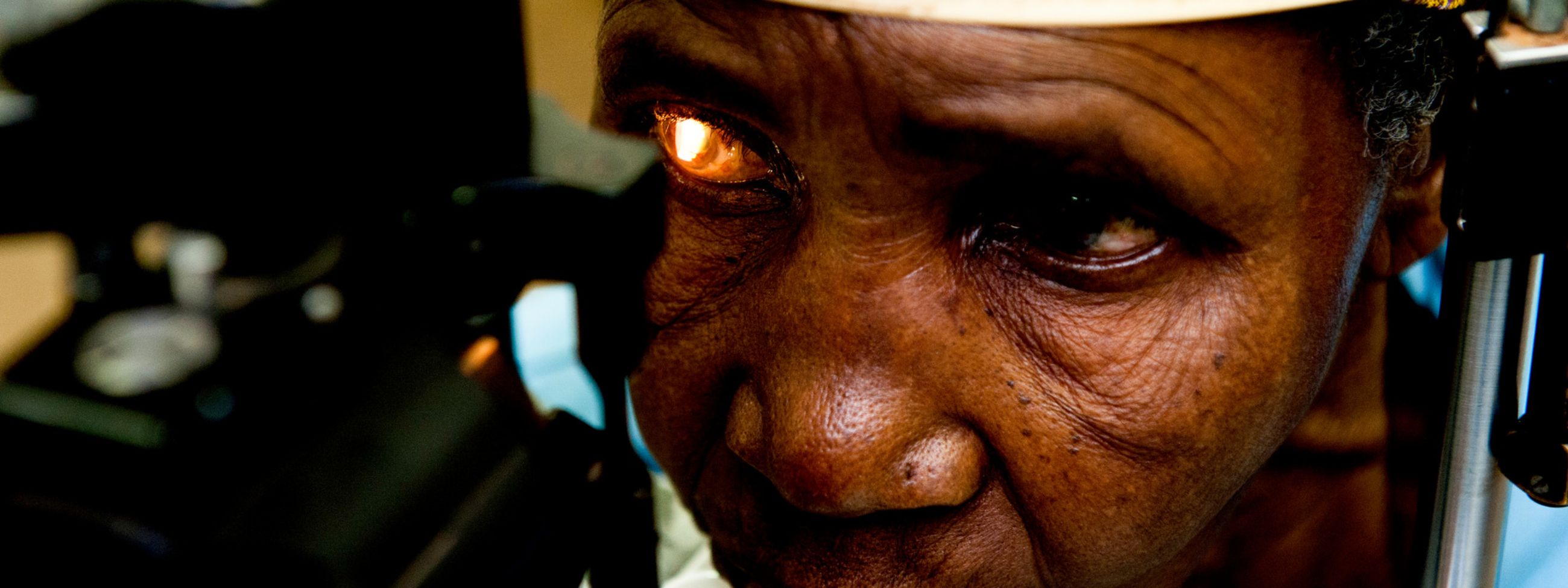 An elderly African woman gets an eye exam.