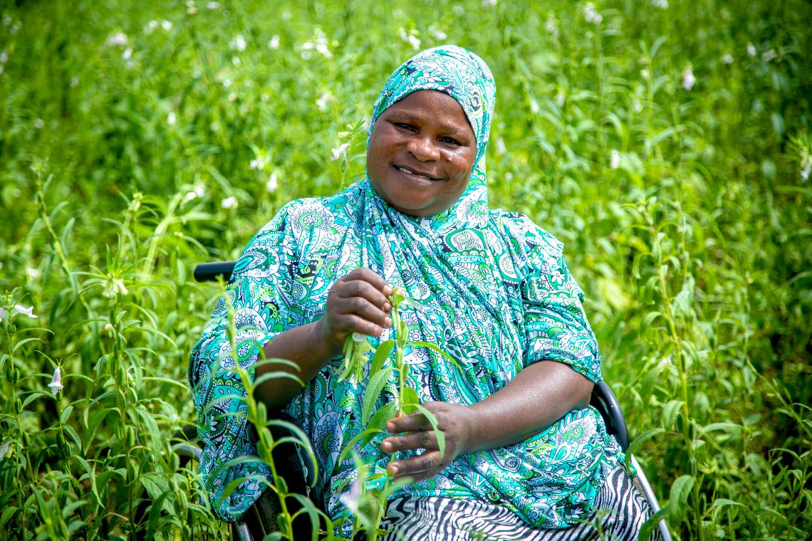 A woman sitting in her wheelchair in a lush green garden
