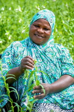 A woman sitting in her wheelchair in a lush green garden