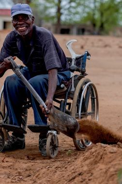 A man using a spade to scoop soil